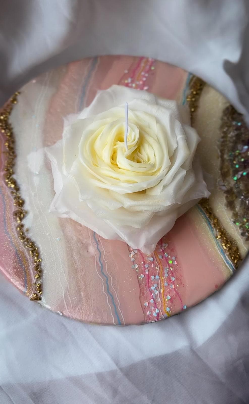 A pastel flower candle arranged for display.