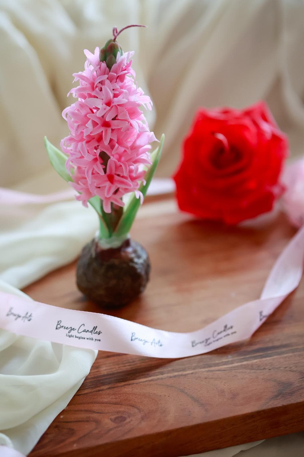 A handmade candle with a sculpted blossom design.